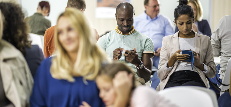Patients sitting on chair and using mobile phone in waiting room.